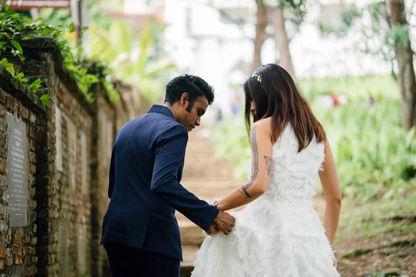 異人種間のカップル インド人 中国人の女性 は日の公園での結婚式の写真のポーズします 古い石段上にある 笑顔と笑いながら写真を取るよう — ストック写真