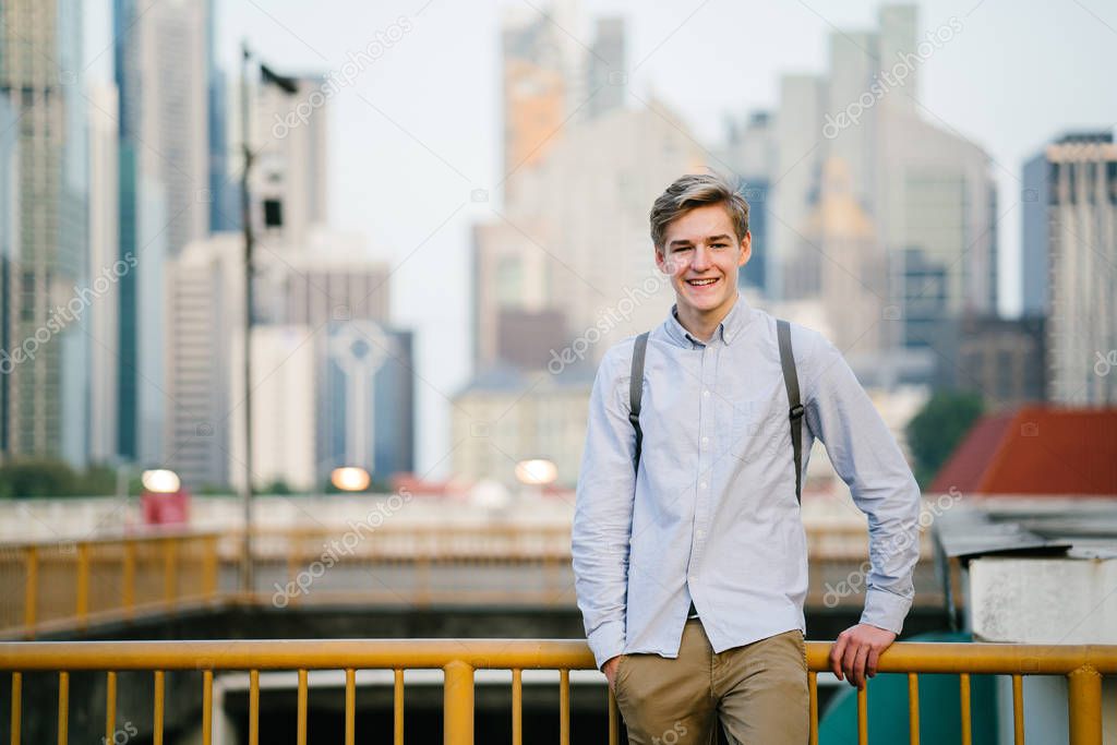 portrait of a young and attractive Caucasian white man (tourist or student)  smiling at sunrise or sunset in  Asia. He is smiling and is relaxed.
