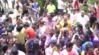 Singapur, 3 Mart 2018: Sentosa Island, Singapur bayram kutlama. Hintliler ve diğer kutlama renkli hamur ve toz birbirlerine yayma ve güneşin büyük bir havuzu müzik dans.