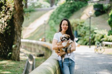 Parkta onun shih tzuh köpek olan bir genç, çekici pan Asya kadın portresi. Onlar ortasında bir yürüyüş ve neşeli ve rahat görünüyorlar.