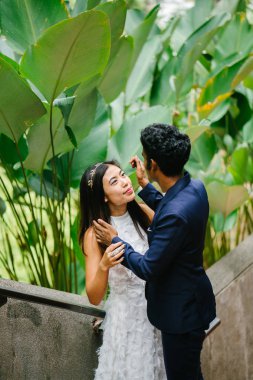 Farklı ırkların çekici bir çift stand birlikte parkta günde Asya'da. Düğün fotoğrafları götürüyorlar. Hintli bir adam, diğer Çinli bir kadını biri.