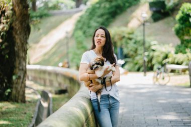 Parkta onun shih tzuh köpek olan bir genç, çekici pan Asya kadın portresi. Onlar ortasında bir yürüyüş ve neşeli ve rahat görünüyorlar.