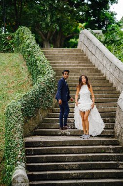 Interracial aşıklar çifti parkta taş merdivenlerden gün boyunca çalıştırın. Bir Hintli Çinli bir kadını evleniyor ve onlar zevk ve neşe içinde merdivenlerden aşağı çalışan.