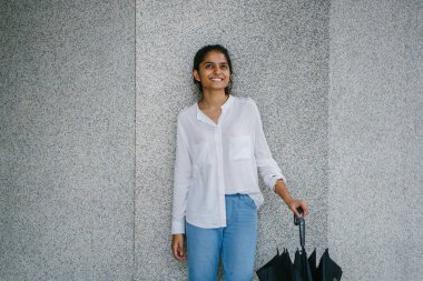 Genç ve çekici Hint Bayan şemsiye ile şehirde yürüyüş 