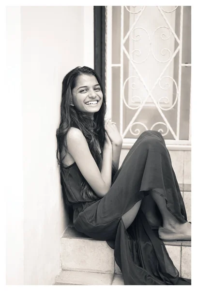 上に座って 若くてエレガントな魅力的なインドのアジア女性の黒と白の肖像画は 日中街のステップします 彼女は笑っています — ストック写真