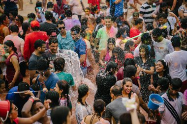 Singapur, 3 Mart 2018: Sentosa Island, Singapur bayram kutlama. Hintliler ve diğer kutlama renkli hamur ve toz birbirlerine yayma ve güneşin büyük bir havuzu müzik dans.