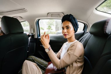 Özel bir limuzin içinde genç, çekici Müslüman kadının portresi. O bir türban giyen ve akıllıca ama mütevazi arka koltukta giyinmiş