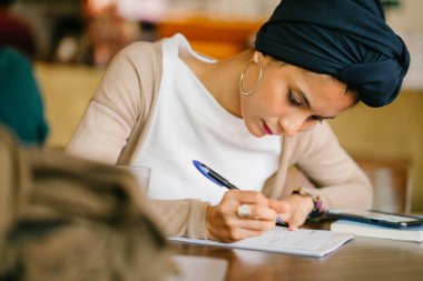 Genç Müslüman bir kadının portresi. O Asya kökenli (Arap, Malay, Asya) ve (türban, Başörtüsü Türban giyiyor) 