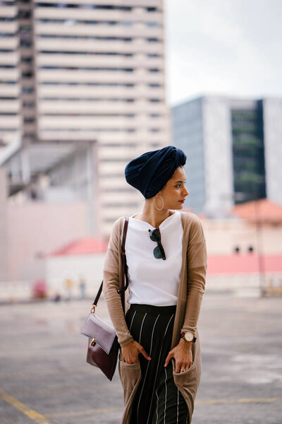 Portrait of a young Muslim woman (Islam) wearing a turban (headscarf, hijab). She is elegant, attractive and professionally dressed.