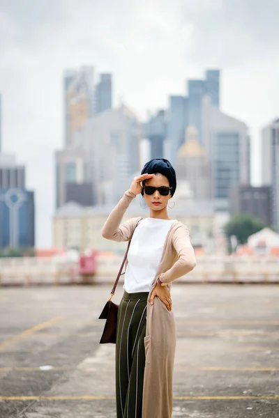 Portrait of a young Muslim woman (Islam) wearing a turban (headscarf, hijab). She is elegant, attractive and professionally dressed.