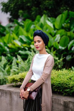 Şehirde bir parkta bir yolda yürüyen bir genç Müslüman kadın portresi. O bir Türban (türban) giyiyor ve uzun boylu, zarif ve güzel. Kadın Malay, Asya ya da Suudi kökenli olduğunu.