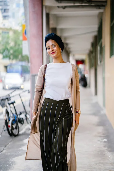 Portrait of a young Muslim woman (Islam) wearing a turban (headscarf, hijab). She is elegant, attractive and professionally dressed.