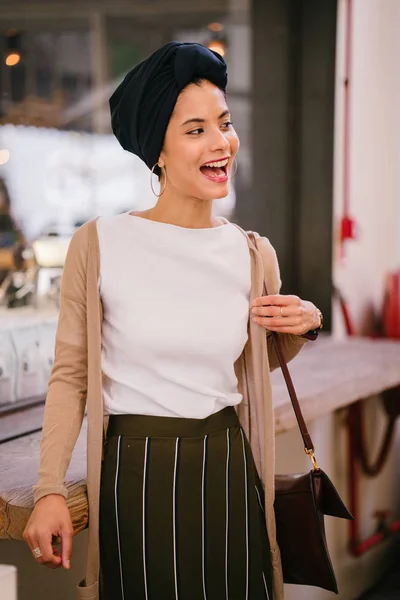 Portrait of a young Muslim woman (Islam) wearing a turban (headscarf, hijab). She is elegant, attractive and professionally dressed.