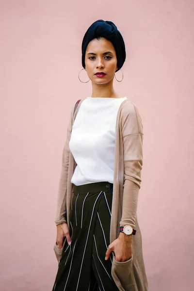 一个美丽的年轻穆斯林妇女在工作室戴头巾的肖像 她穿着优雅 站在一个普通的粉红色背景 — 图库照片