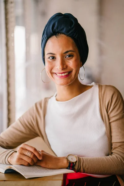 有吸引力的穆斯林妇女 阿拉伯人 马来语 亚洲人 读一本书在咖啡馆的窗口在白天 她戴着头巾 Hijabi 穿着优雅的泥土色调 — 图库照片