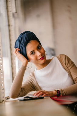 genç, çekici Müslüman kadın (Arap, Malay, Asya) günde bir kafe pencere tarafından bir kitap okur. O bir Türban (başörtüsü, hijabi) giyiyor ve dünyevi tonlarda zarif giyinmiş.