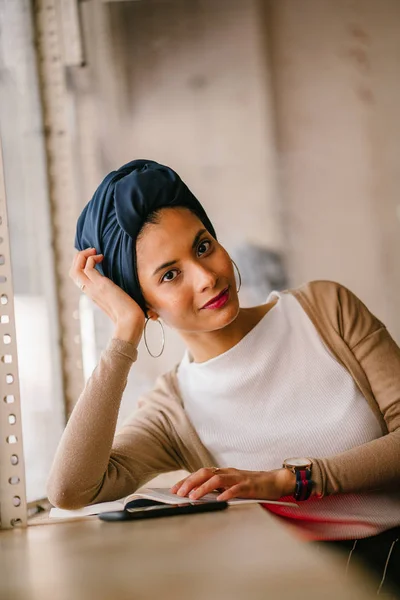 アラブ マレー語 アジア 魅力的なイスラム教徒の女性は 朝カフェの窓で本を読みます 彼女は身に着けているターバン スカーフ Hijabi と素朴な色調でエレガントな服を着て — ストック写真