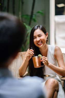 bir adam ile romantik bir tarih üzerinde genç Çinli Asyalı kadın. O ise alkollü bir içecek gülümsüyor, gülüyor ve görüşmeler bir güzel bar veya kafe onun tarihle içiyor.