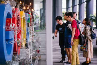 Singapur, Mart 2018: Google'nın yeni kampüs lobisinde Google logosu ve office bölgesel HQ Singapur fotoğrafı. Bir grup insan müzik chimes bir tekerlek çevirmek.