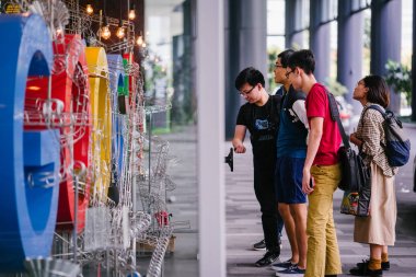 Singapur, Mart 2018: Google'nın yeni kampüs lobisinde Google logosu ve office bölgesel HQ Singapur fotoğrafı. Bir grup insan müzik chimes bir tekerlek çevirmek.