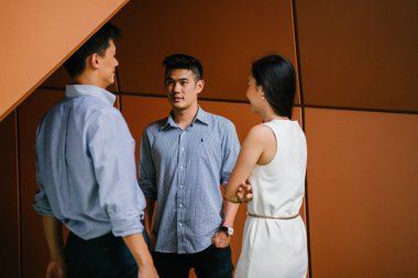 üç iş profesyonelleri (avukat, bankacılar veya muhasebeciler) ekip var bir konuşma / gün onların Office tartışma. İki Çinli Asyalı erkek ve bir kadın yan yana ve bahsediyorsun.