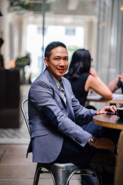 Grup Asya iş bir masa etrafında oturup çalışmaları hakkında sohbet vardır. Onlar konuşurken onlar gülümseyen ve rahat.