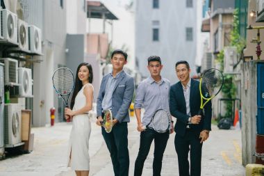 portre profesyonel iş adamları ile tenis raketi. Asya'da bir şehirde bir sokakta yürürken derin konuşmada değilsiniz