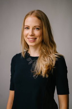 Beyaz bir arka plan karşı bir profesyonel, çekici ve sarışın Rus kadın portresi. O bir expat Asya ve siyah bir elbise giyiyor ve güven projeler iken gülümsüyor.