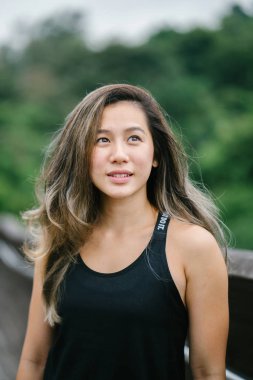 Çekici, genç Çinli Asyalı bir kadın portresi sportif, aktif giyim Singapur genel Park'ta hafta sonu gün içinde giyinmiş.