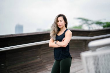 Çekici, genç Çinli Asyalı bir kadın portresi sportif, aktif giyim Singapur genel Park'ta hafta sonu gün içinde giyinmiş.