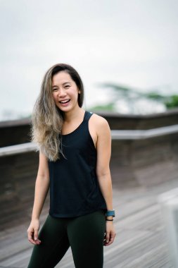 Çekici, genç Çinli Asyalı bir kadın portresi sportif, aktif giyim Singapur genel Park'ta hafta sonu gün içinde giyinmiş.