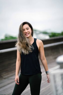Çekici, genç Çinli Asyalı bir kadın portresi sportif, aktif giyim Singapur genel Park'ta hafta sonu gün içinde giyinmiş.