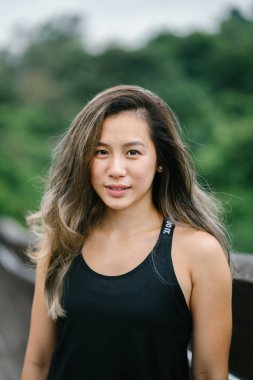 Çekici, genç Çinli Asyalı bir kadın portresi sportif, aktif giyim Singapur genel Park'ta hafta sonu gün içinde giyinmiş.