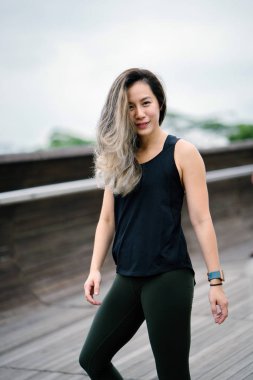 Çekici, genç Çinli Asyalı bir kadın portresi sportif, aktif giyim Singapur genel Park'ta hafta sonu gün içinde giyinmiş.