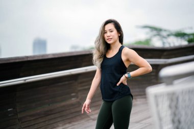 Çekici, genç Çinli Asyalı bir kadın portresi sportif, aktif giyim Singapur genel Park'ta hafta sonu gün içinde giyinmiş.