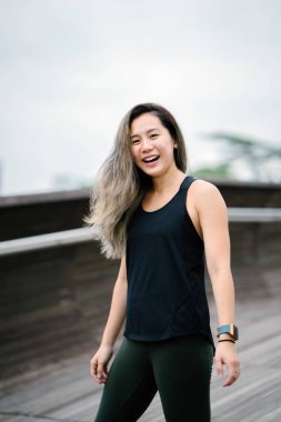 Çekici, genç Çinli Asyalı bir kadın portresi sportif, aktif giyim Singapur genel Park'ta hafta sonu gün içinde giyinmiş.