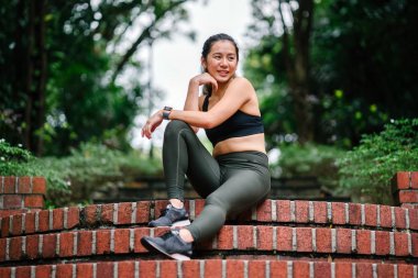 Bir köprü bir parkta gür, yeşil genel Singapur sportif, aktif giyim gün hafta sonu boyunca çekici, genç Çinli Asyalı bir kadın portresi giymiş.