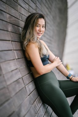 Çekici, genç Çinli Asyalı bir kadın portresi sportif, aktif giyim Singapur genel Park'ta hafta sonu gün içinde giyinmiş.