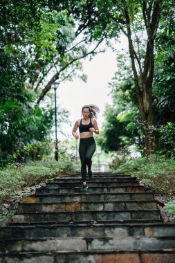 merdivenlerden aşağı bir yol Singapur genel bir parkta onu hafta sonu egzersiz sırasında çalışan sportif, aktif giyim giymiş çekici, genç Çinli Asyalı kadın.