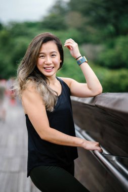 Çekici, genç Çinli Asyalı bir kadın portresi sportif, aktif giyim Singapur genel Park'ta hafta sonu gün içinde giyinmiş.