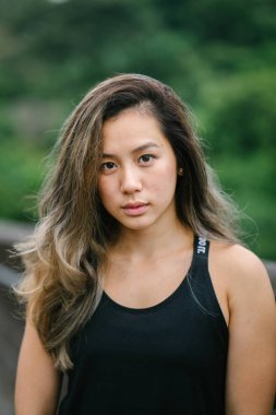 Çekici, genç Çinli Asyalı bir kadın portresi sportif, aktif giyim Singapur genel Park'ta hafta sonu gün içinde giyinmiş.