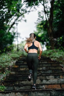 merdivenlerden aşağı bir yol Singapur genel bir parkta onu hafta sonu egzersiz sırasında çalışan sportif, aktif giyim giymiş çekici, genç Çinli Asyalı kadın.