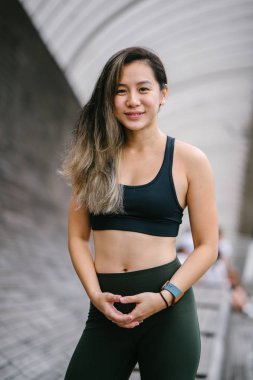 Çekici, genç Çinli Asyalı bir kadın portresi sportif, aktif giyim Singapur genel Park'ta hafta sonu gün içinde giyinmiş.