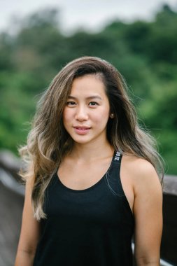 Çekici, genç Çinli Asyalı bir kadın portresi sportif, aktif giyim Singapur genel Park'ta hafta sonu gün içinde giyinmiş.