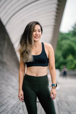 Çekici, genç Çinli Asyalı bir kadın portresi sportif, aktif giyim Singapur genel Park'ta hafta sonu gün içinde giyinmiş.