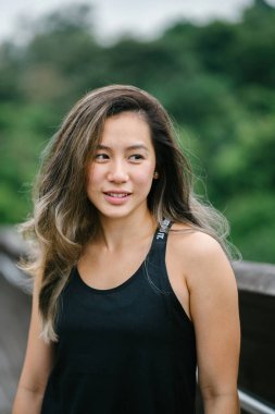 Çekici, genç Çinli Asyalı bir kadın portresi sportif, aktif giyim Singapur genel Park'ta hafta sonu gün içinde giyinmiş.