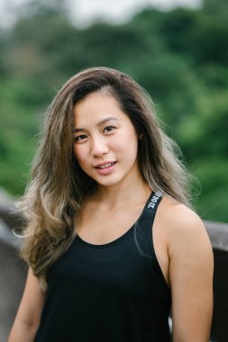 Çekici, genç Çinli Asyalı bir kadın portresi sportif, aktif giyim Singapur genel Park'ta hafta sonu gün içinde giyinmiş.