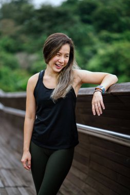 Çekici, genç Çinli Asyalı bir kadın portresi sportif, aktif giyim Singapur genel Park'ta hafta sonu gün içinde giyinmiş.