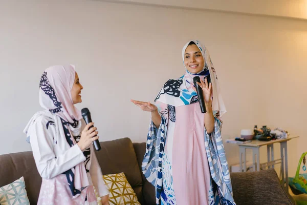 Duas Mulheres Muçulmanas Lenços Cabeça Estão Cantando Karaoke Seu Sistema — Fotografia de Stock