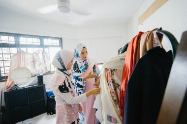 İki genç ve çekici Müslüman kadın girişimciler iş tartışma perakende ofis içinde yaşıyoruz. Onlar hem baş eşarp (hjiab) giyiyor ve kendi çalışmaları hakkında yoğun bir konuşmayı.